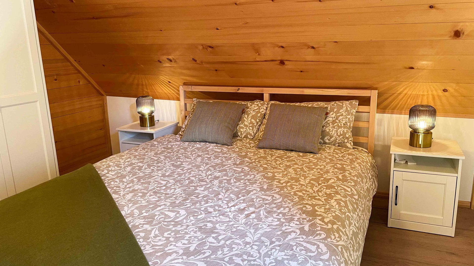 Kuća Amalia – bračni krevet s cvjetnom posteljinom pod drvenim stropom